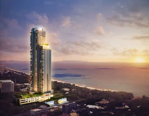 The Panora Pattaya high-rise condo building at sunset, overlooking the ocean and coastline.
