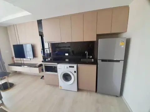 Studio Condo for Rent at The Panora Pattaya kitchenette with refrigerator, washing machine and wood cabinetry