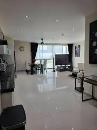 2 Bedroom Condo for Sale at The Park Jomtien living and dining area with large window and TV