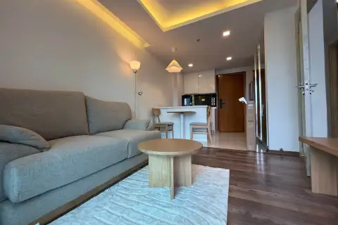 1 Bedroom Condo for Rent at The Peak Towers open-plan living area with sofa, dining table, and entrance door