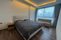 1 Bedroom Condo for Rent at The Peak Towers bedroom with upholstered bed, bedside lounge sofa, and city view