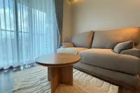 1 Bedroom Condo for Rent at The Peak Towers cozy seating nook with round wooden coffee table and gray sofa by window