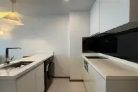1 Bedroom Condo for Rent at The Peak Towers modern kitchen with white cabinetry, built-in stove, and washing machine