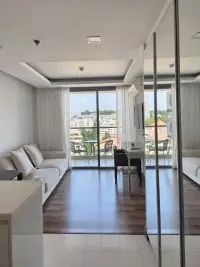 1 Bedroom Condo for Rent at The Peak Towers living room with sofa, wooden desk, and city view balcony
