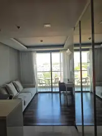 1 Bedroom Condo for Rent at The Peak Towers living room with sofa and mirrored wardrobe facing balcony