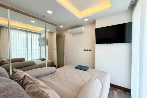 2 Bedroom Condo for Rent at The Peak Towers bedroom with wall-mounted TV and air conditioning unit