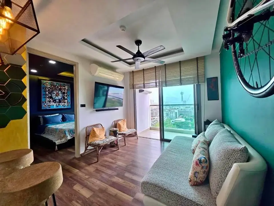 1 Bedroom Condo for Sale at The Peak Towers living room with teal accent wall, bicycle display, and city view balcony