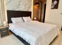 2 Bedroom Condo for Sale at The Point Pratumnak master bedroom with marble feature wall and dark headboard