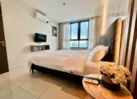 2 Bedroom Condo for Sale at The Point Pratumnak bedroom with ocean view window and flat-screen TV