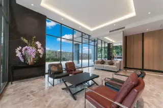 The Point Pratumnak modern lobby lounge with marble floors, dark accent walls, and comfortable seating.