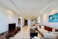 2 Bedroom Condo for Sale at The Residence Jomtien open-plan living room with rattan sofa and kitchen view