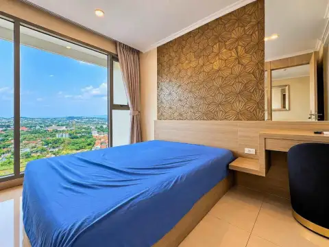1 Bedroom Condo for Rent at The Riviera Jomtien bedroom with blue bedding and panoramic window view