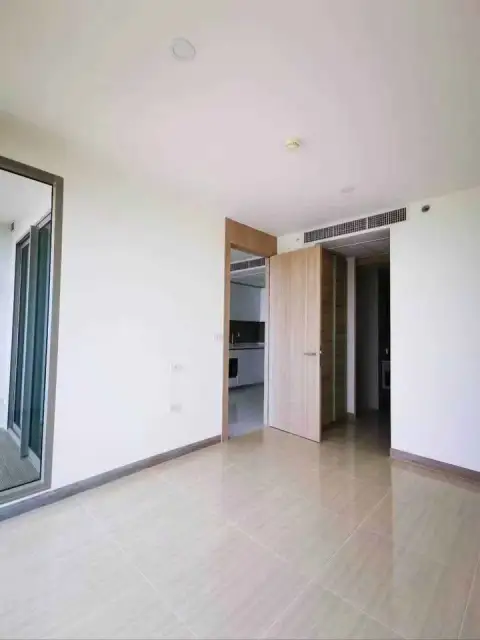 1 Bedroom Condo for Sale at The Riviera Jomtien empty living room with tiled flooring and hallway entrance