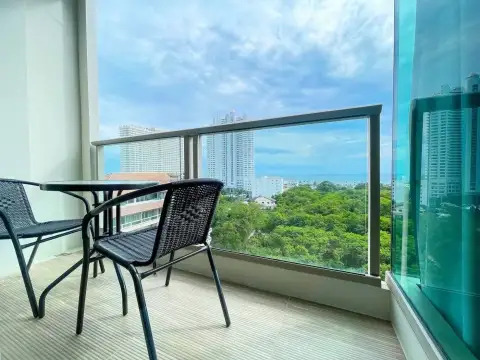 1 Bedroom Condo for Rent at The Riviera Jomtien balcony seating area with table, chairs, and skyline view