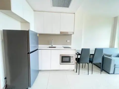 1 Bedroom Condo for Rent at The Riviera Jomtien kitchen with refrigerator, microwave, and white cabinetry