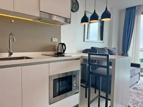 1 Bedroom Condo for Rent at The Riviera Jomtien compact kitchen with built-in microwave and bar seating
