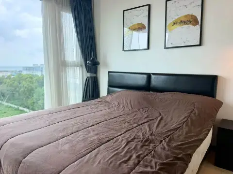 1 Bedroom Condo for Rent at The Riviera Jomtien bedroom with king bed, wall art and sea glimpse