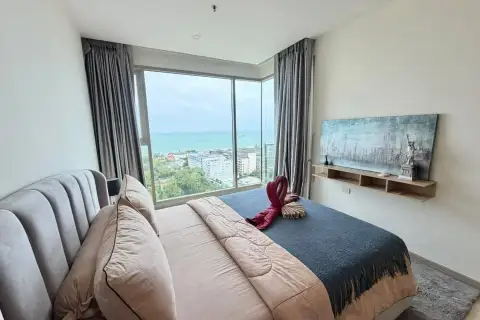 2 Bedroom Condo for Rent at The Riviera Jomtien bedroom with ocean view and towel art on bed