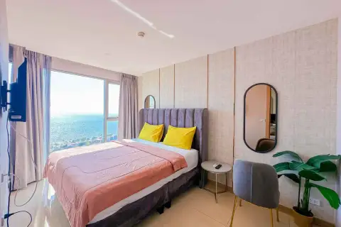 2 Bedroom Condo for Rent at The Riviera Jomtien bedroom with sea view window and velvet grey headboard