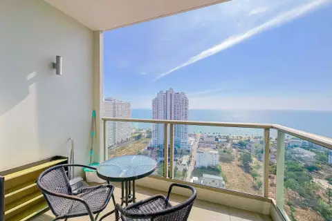 2 Bedroom Condo for Rent at The Riviera Jomtien private balcony with rattan chairs and panoramic ocean view