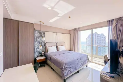2 Bedroom Condo for Rent at The Riviera Jomtien bedroom with high-rise city view through floor-to-ceiling window