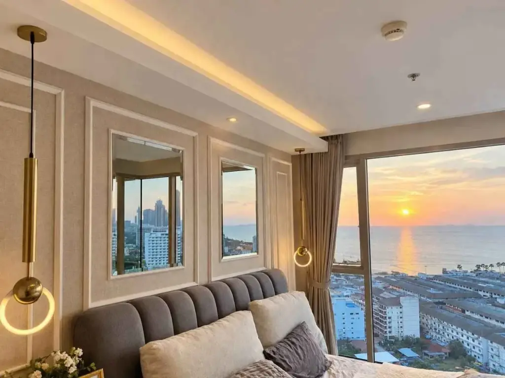 2 Bedroom Condo for Rent at The Riviera Jomtien bedroom with panoramic sunset sea view and gold pendant lights