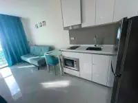 1 Bedroom Condo for Sale at The Riviera Jomtien modern kitchenette with white cabinets and black fridge