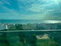 1 Bedroom Condo for Sale at The Riviera Jomtien balcony view of ocean, coastline and city buildings