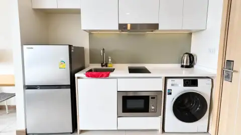 Studio Condo for Rent at The Riviera Jomtien kitchenette with refrigerator, microwave and built-in washing machine