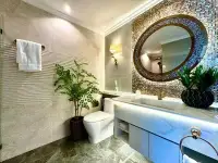 1 Bedroom Condo for Sale at The Riviera Malibu bathroom with round mosaic mirror and marble vanity