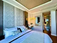 1 Bedroom Condo for Sale at The Riviera Malibu bedroom with upholstered headboard and decorative mirror