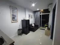 1 Bedroom Condo for Rent at The Twin Tower Jomtien Beach Pattaya living room with sofa, wall art, and balcony access at night