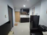 1 Bedroom Condo for Rent at The Twin Tower Jomtien Beach Pattaya hallway view with kitchenette, black fridge, and wooden entry door