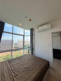 1 Bedroom Condo for Rent at The Twin Tower Jomtien Beach Pattaya bed by panoramic window overlooking Pattaya skyline