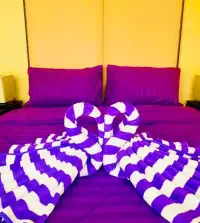 3 Bedroom House for Rent at The Ville Jomtien bedroom with purple bedding and decorative towel swan art