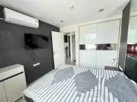 1 Bedroom Condo for Sale at The Vision bedroom with wall-mounted TV, white wardrobe, and air conditioner