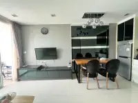 1 Bedroom Condo for Sale at The Vision dining area with black chairs, TV unit, and stainless fridge