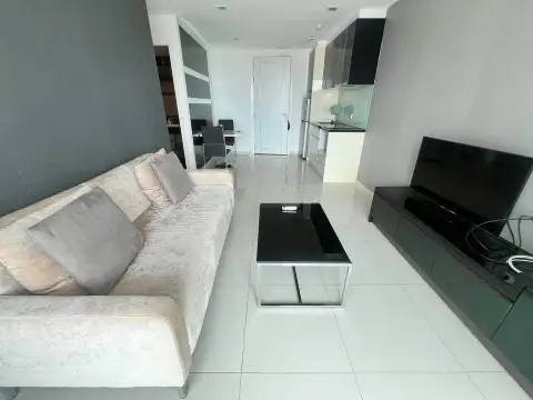 1 Bedroom Condo for Sale at The Vision living area with beige sofa, glass coffee table and view into kitchen and entrance