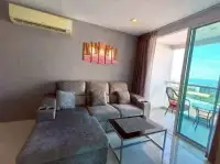 1 Bedroom Condo for Sale at The Vision cozy living room with sectional sofa and sea view balcony