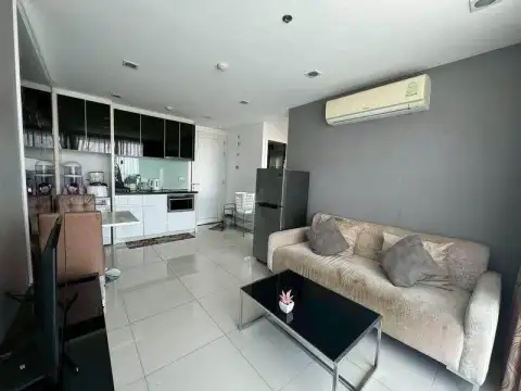 1 Bedroom Condo for Sale at The Vision living room with beige sofa, kitchenette and wall-mounted air conditioner