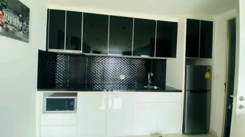 1 Bedroom Condo for Rent at The Vision kitchen with black cabinets, built-in microwave, and stainless fridge