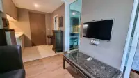 1 Bedroom Condo for Sale at The Winner Pratumnak living room with wall-mounted TV, carved coffee table and entry hallway