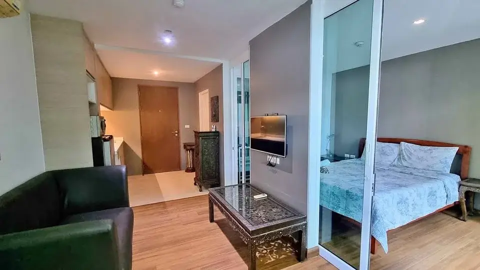 1 Bedroom Condo for Sale at The Winner Pratumnak open-plan living area with sofa, glass partition and bedroom view