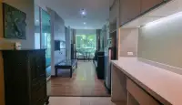 1 Bedroom Condo for Sale at The Winner Pratumnak hallway view toward living room with balcony and greenery outside