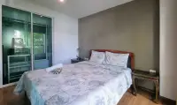 1 Bedroom Condo for Sale at The Winner Pratumnak bedroom with wooden bed, balcony door and nightstand