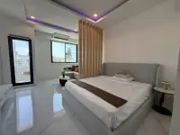 Studio Condo for Sale at Thepthip Mansion Condominium bedroom with gray upholstered bed, wood slat divider, and balcony views