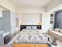 Studio Condo for Rent at Thian Tong Condotel bedroom area with wood-frame bed, wardrobe, and sofa