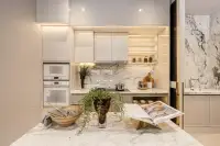 4 Bedroom House for Sale at Cascade modern kitchen with marble island countertop, built-in ovens, marble backsplash, and under-cabinet LED lighting