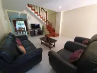 2 Bedroom Townhouse for Rent in Pratumnak Hill living room with black leather sofas and wooden staircase