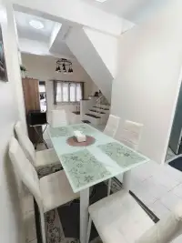 2 Bedroom Townhouse for Rent in East Pattaya dining area with glass table, white chairs, and staircase view